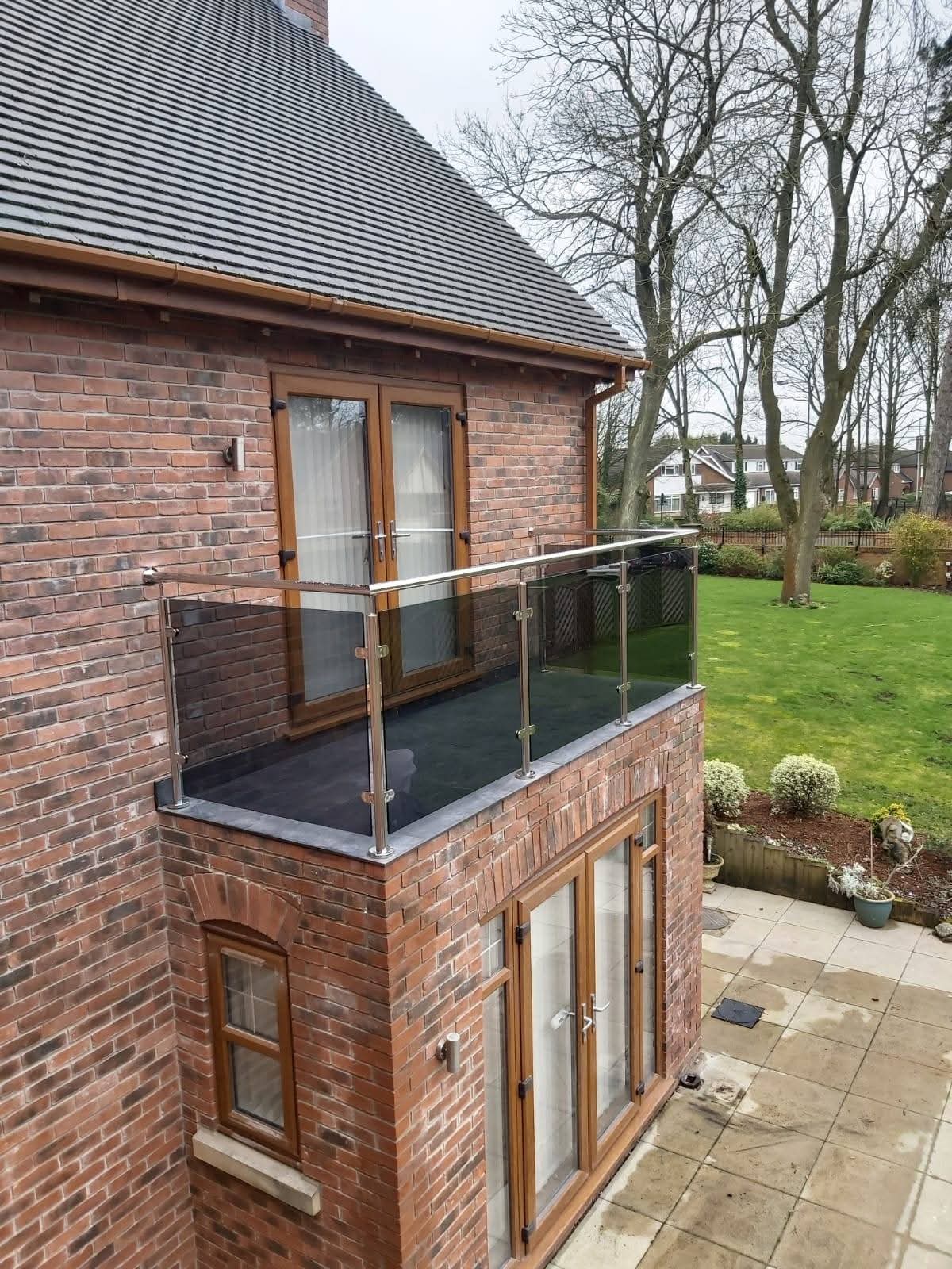 New brick extension with glass balustrade balcony