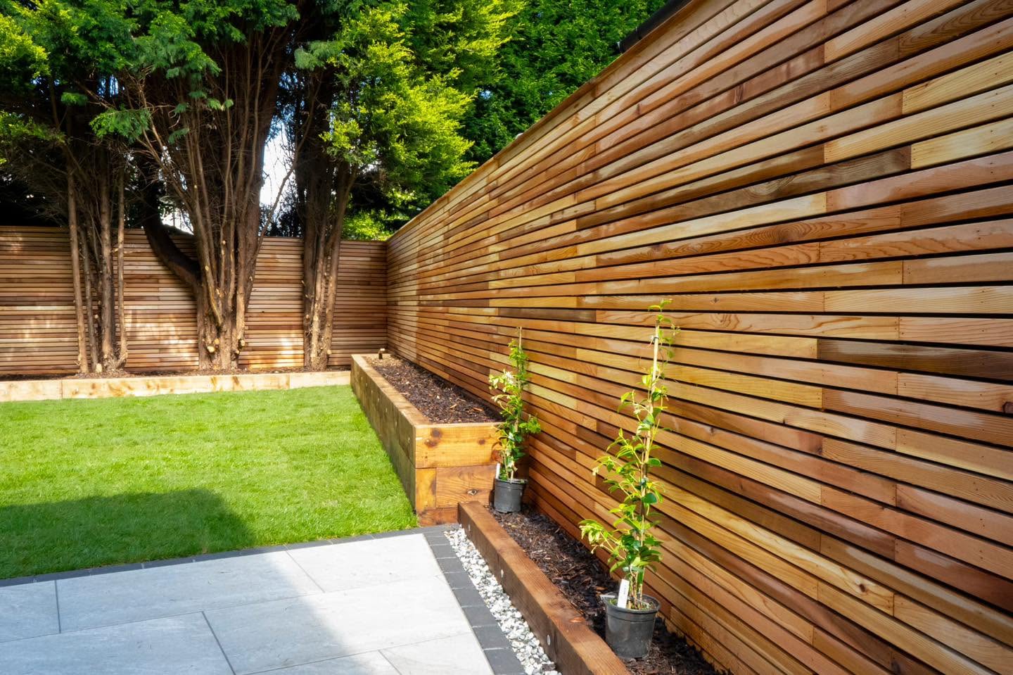 Cedar slatted fence screening with lawn